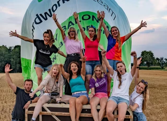 uśmiechnięci ludzie na tle balonu