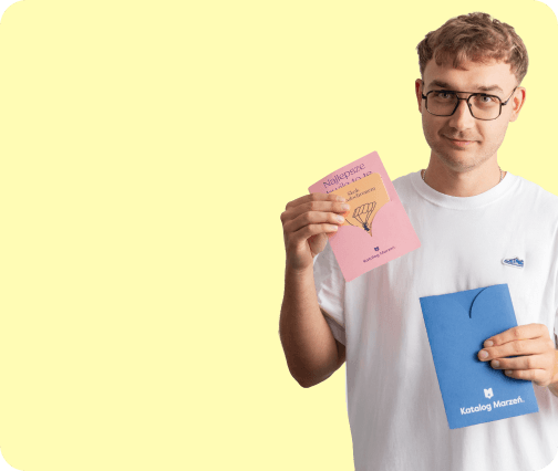 Mężczyzna trzymający voucher i kopertę prezentową Katalog Marzeń
