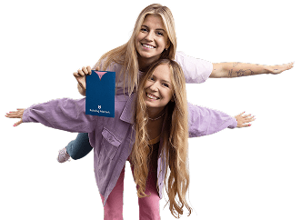 Dwie uśmiechnięte kobiety z rozłożonymi rękami, jedna trzyma voucher Katalog Marzeń.
