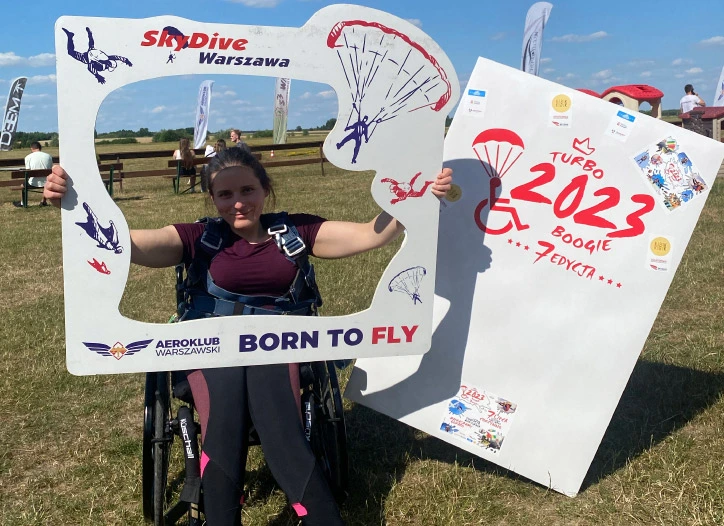 kobieta na wózku inwalidzkim trzyma tablicę