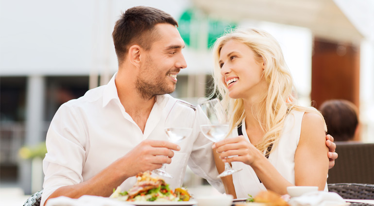 Uśmiechnięta Kobieta i Mężczyzna podczas Kolacji w Restauracji