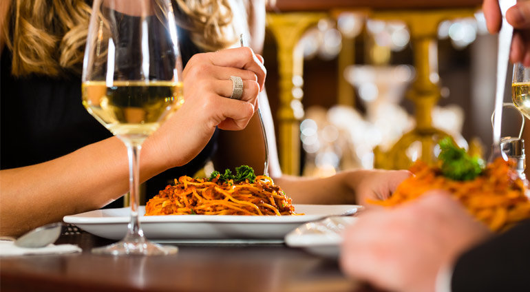 kobieta podczas kolacji z partnerem - spaghetii i wino