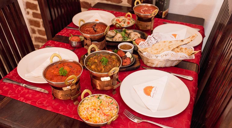 suto zastawiony stół potrawami indyjskimi