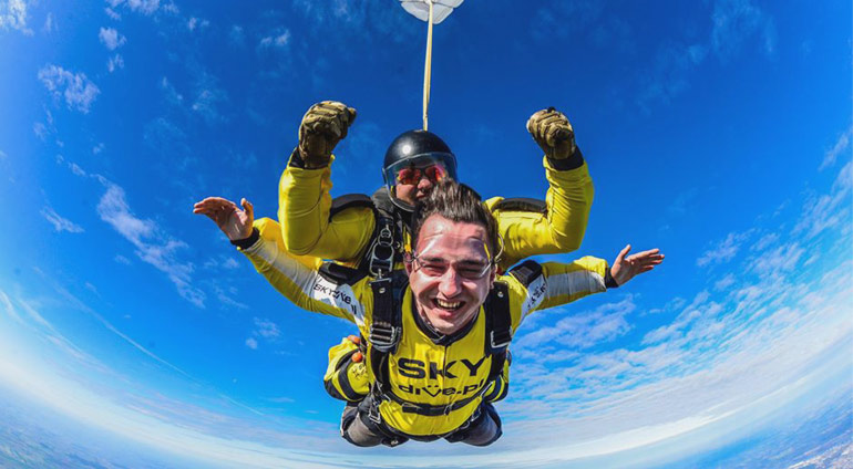 Mężczyzna wyskakuje ze spadochronem w SkyDive Włocławek