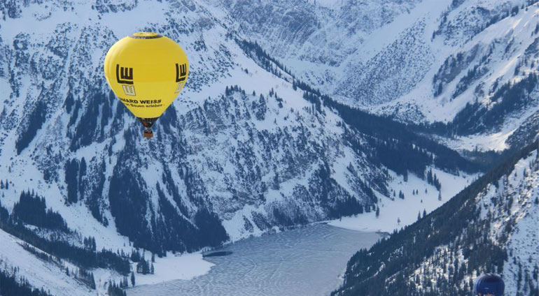 Żółty lot balonem podczas lotu nad górami