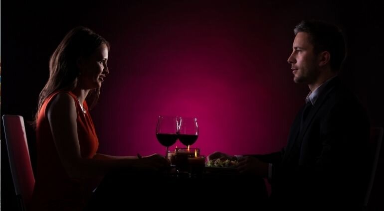 Kobieta I Mężczyzna Uśmiechają Się Do Siebie Pijac Wino W Ciemności