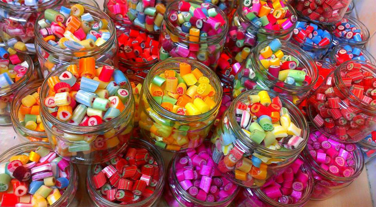 kolorowe cukierki w słoikach leżą na stole