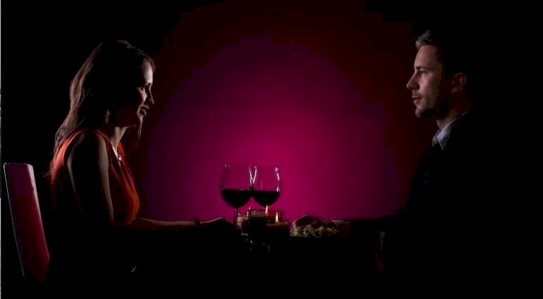 Kobieta I Mężczyzna Uśmiechają Się Do Siebie Pijac Wino W Ciemności