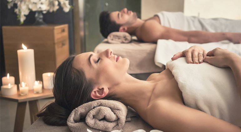Młodsa para błogo relaksuje się w spa podczas masażu