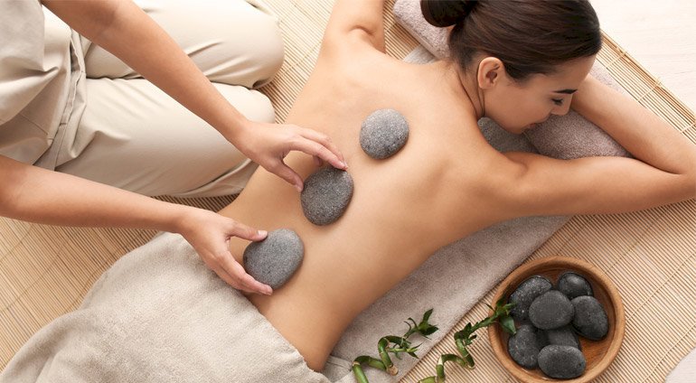 Masażystka kładzie kamienie podczas masażu