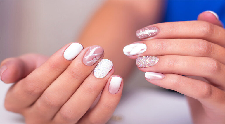 jasny manicure na dłoniach z brokatowym lakierem