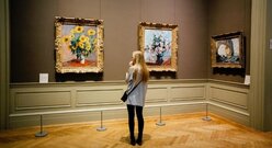 Kobieta Przypatruje Się Trzem Obrazom W Muzeum