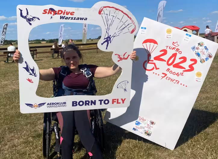 kobieta na wózku inwalidzkim trzyma tablicę